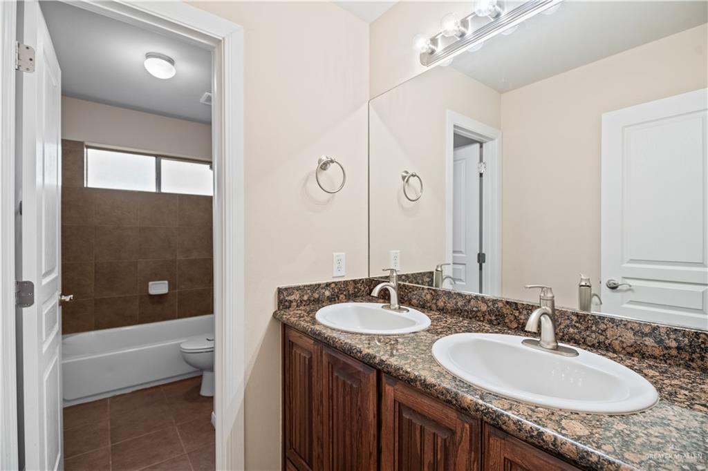 2806 San Ricardo Street Mission, TX 78572 - Photo 18 of 29 a bathroom with a granite countertop double vanity sink and mirror with shower