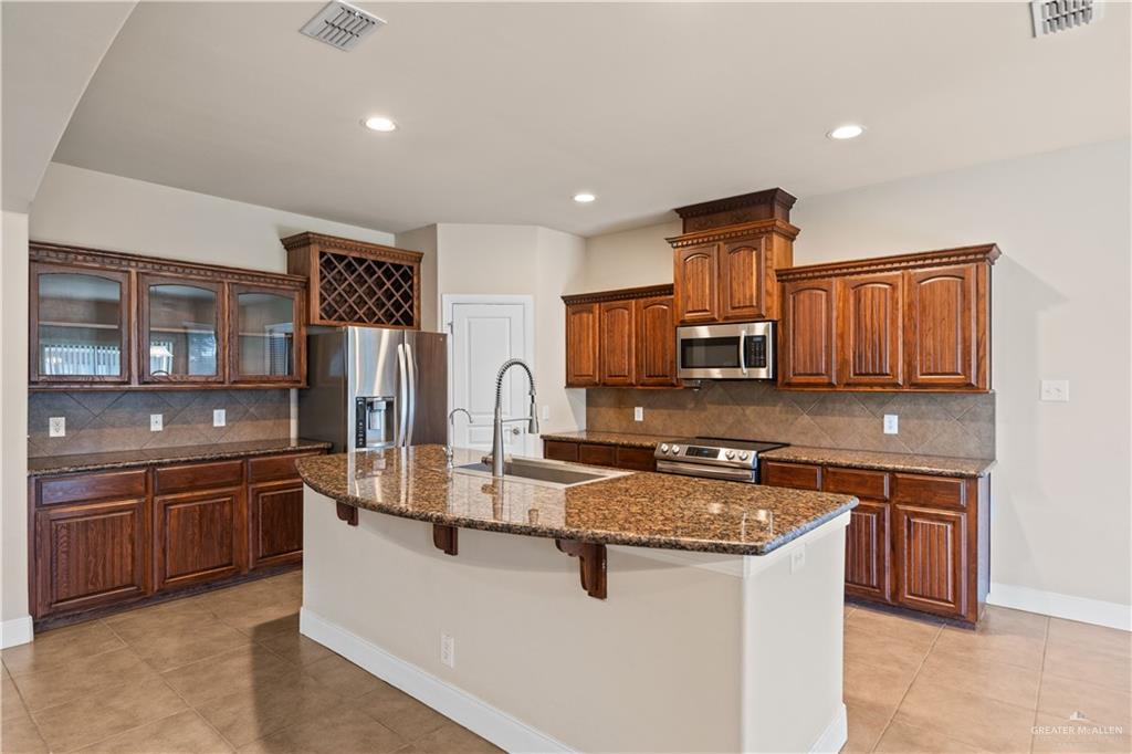 2806 San Ricardo Street Mission, TX 78572 - Photo 7 of 29 a kitchen with stainless steel appliances granite countertop a sink stove and refrigerator