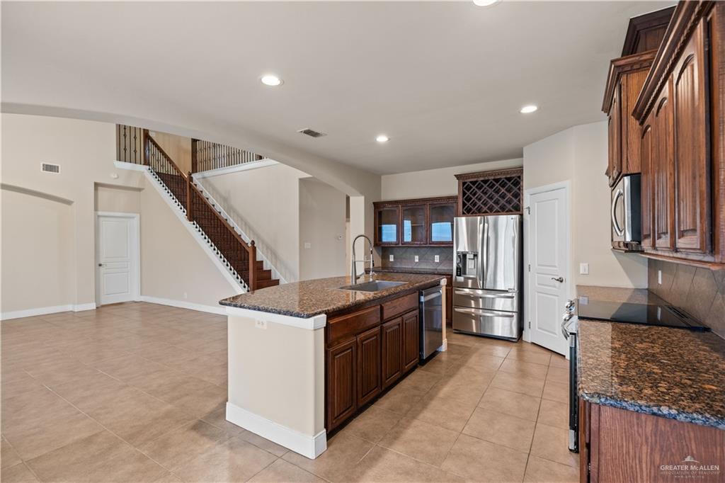 2806 San Ricardo Street Mission, TX 78572 - Photo 9 of 29 a kitchen with stainless steel appliances granite countertop a stove and a refrigerator