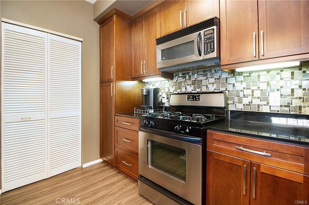2420 Scholarship Irvine, CA 92612 - Photo 5 of 17 a kitchen with granite countertop cabinets stainless steel appliances and wooden floor