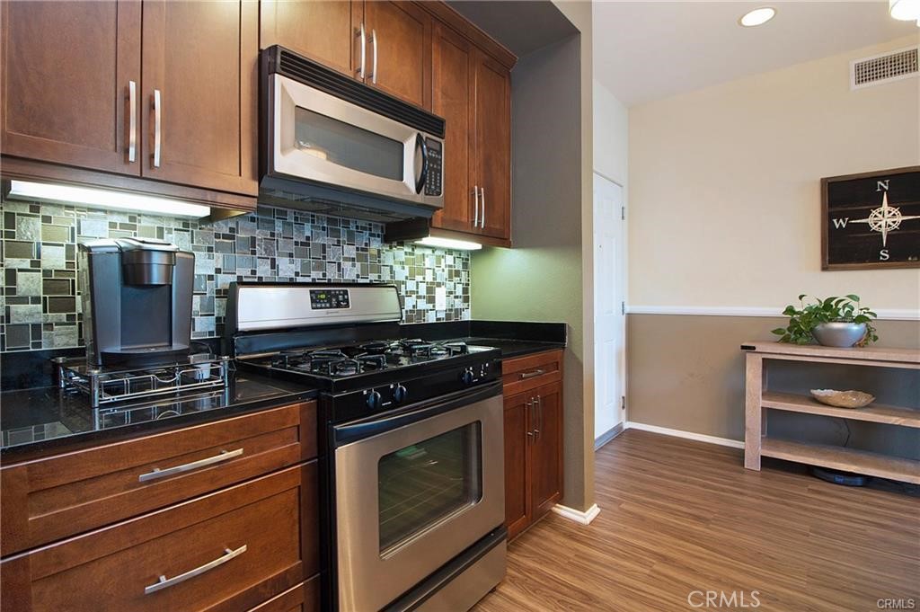 2420 Scholarship Irvine, CA 92612 - Photo 6 of 17 a kitchen with stainless steel appliances a stove a microwave and cabinets