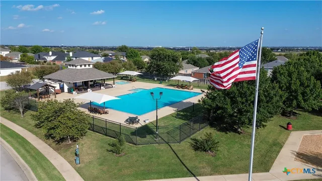 an aerial view of a house with swimming pool and outdoor seating