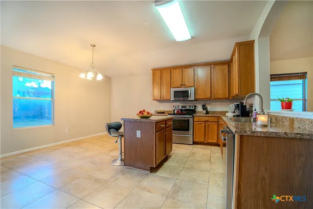 a kitchen with stainless steel appliances granite countertop a sink counter space cabinets and a large window