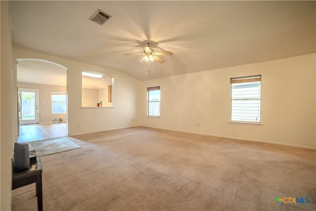an empty room with windows and fan