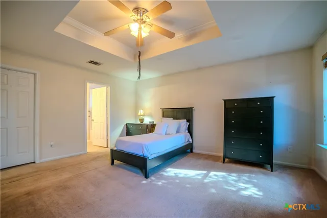 a spacious bedroom with a bed and a chandelier
