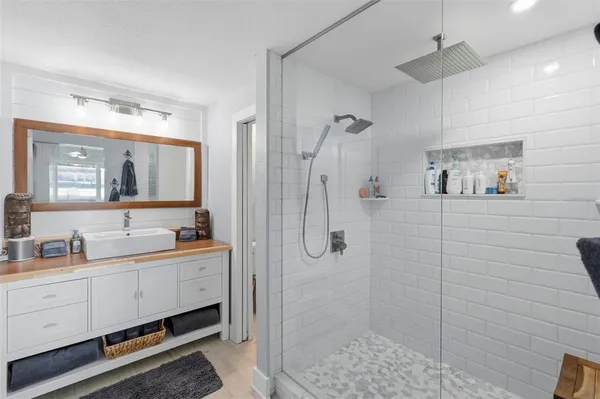 a bathroom with a double vanity sink a toilet a mirror and shower