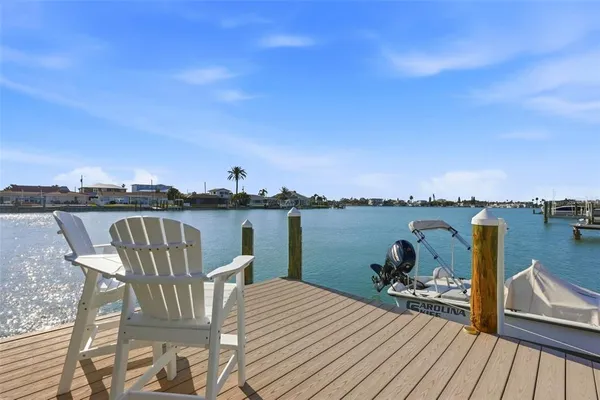 a view of a roof deck with table and chairs a barbeque with wooden floor and fence