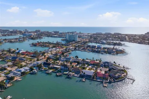 an aerial view of a city with lots of residential buildings ocean and mountain view in back