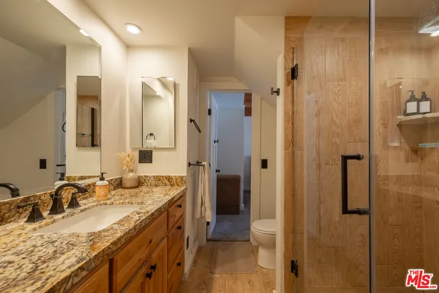 a bathroom with a granite countertop sink and a mirror