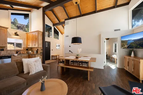 a living room with furniture a flat screen tv and kitchen view