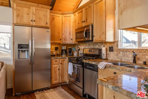 a kitchen with stainless steel appliances granite countertop a refrigerator stove and sink