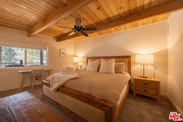 a bedroom with a bed a chandelier and a window