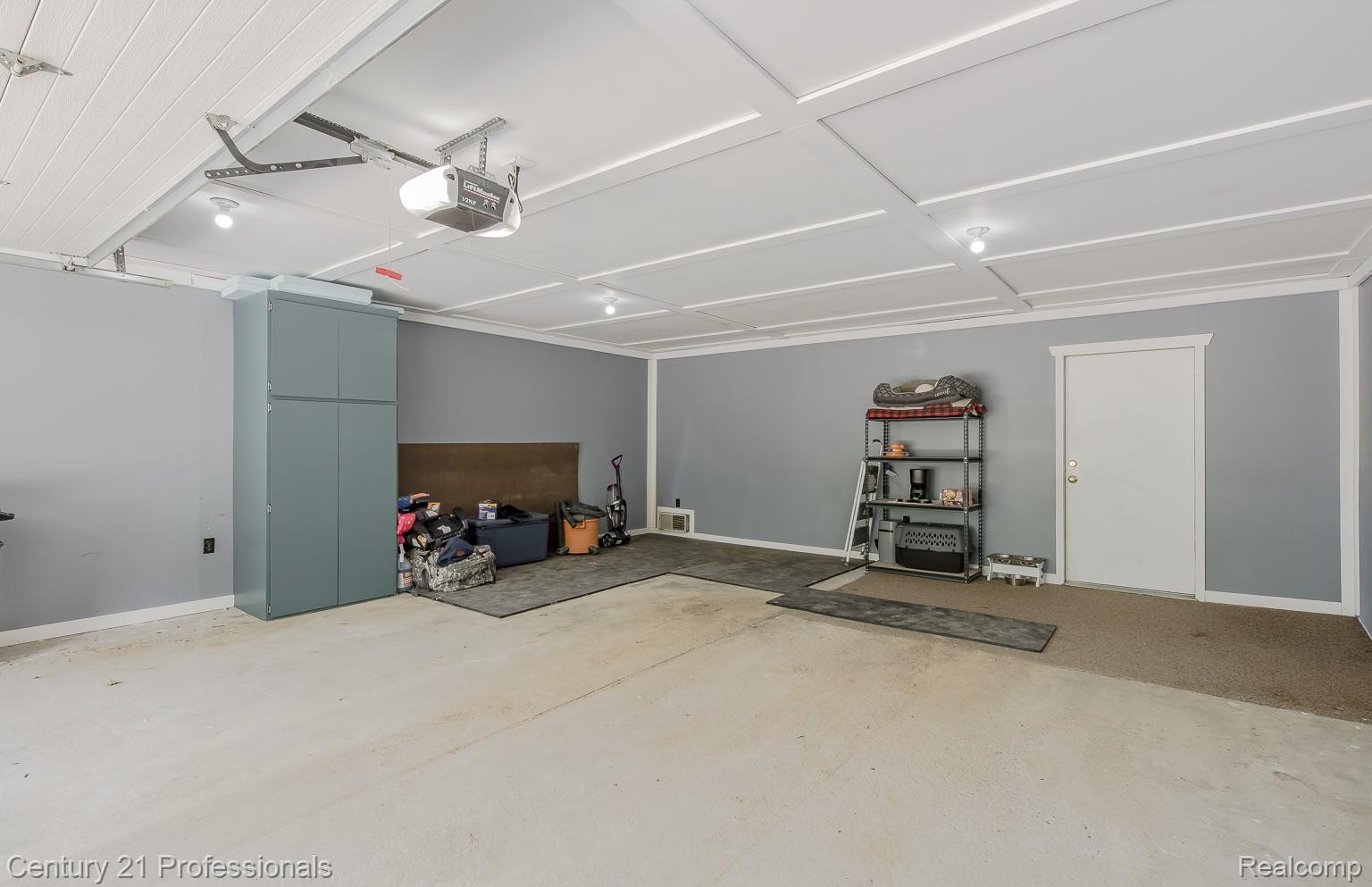 1790 Kent Road Ortonville, MI 48462 - Photo 28 of 64 Spacious garage featuring a coffered ceiling, recessed lighting, concrete flooring, built-in cabinetry, and a service door