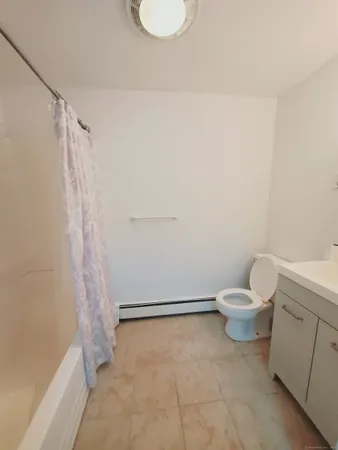 a white toilet sitting next to a bath tub
