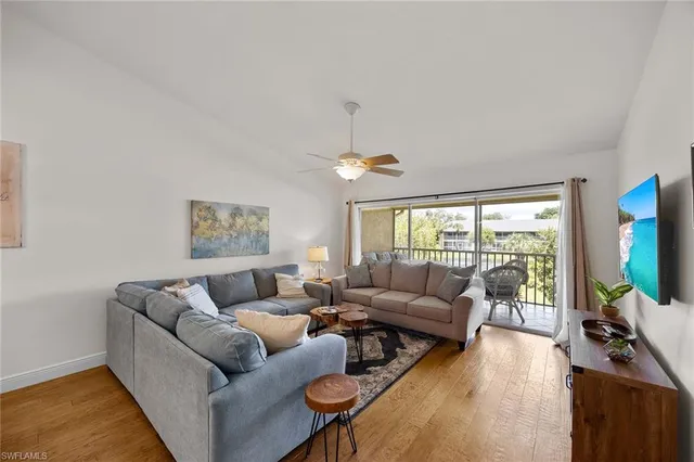 a living room with furniture a flat screen tv and a large window