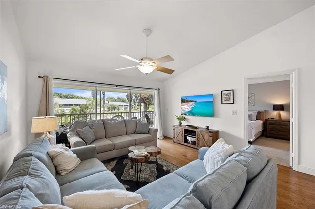 a living room with furniture a large window and a flat screen tv