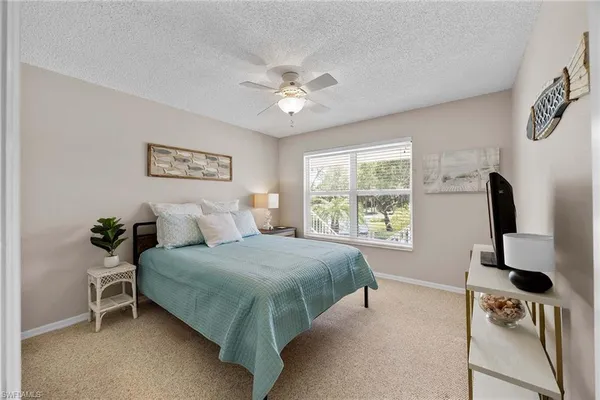 a bedroom with a bed and a flat tv screen on the dresser