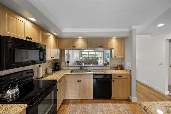 a kitchen with a sink stove top oven and cabinets