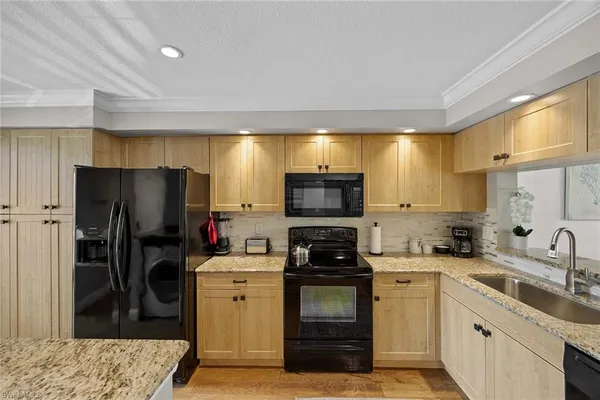a kitchen with a sink a refrigerator and a stove top oven