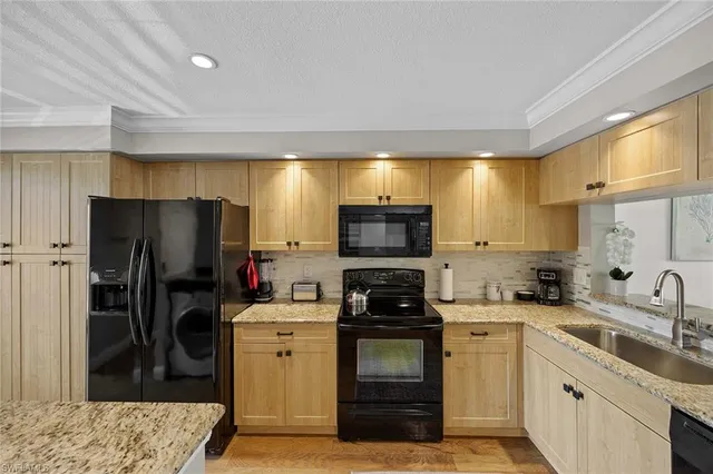 a kitchen with a sink a refrigerator and a stove top oven