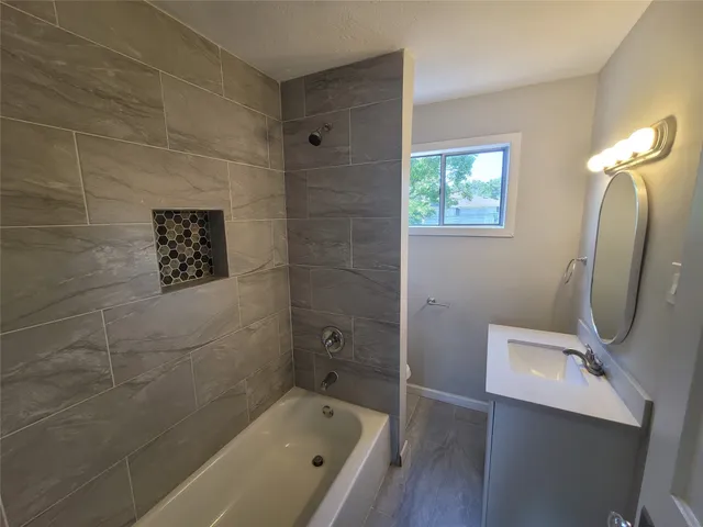 a bathroom with a tub a sink and a shower