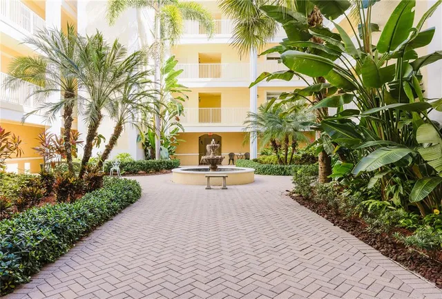 a view of swimming pool with a patio and palm tree