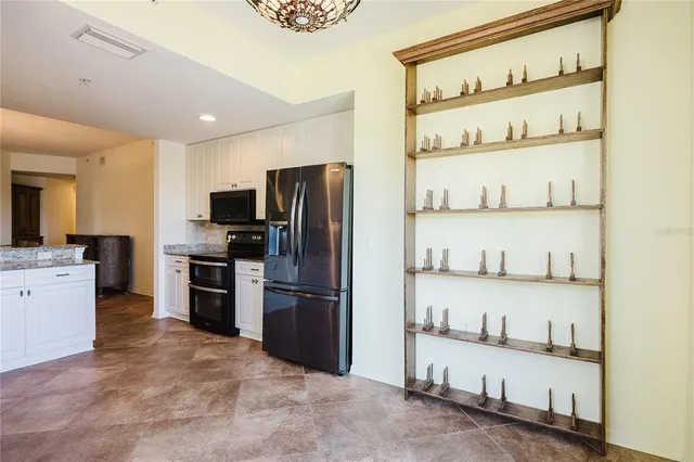 a kitchen with granite countertop white cabinets and white appliances