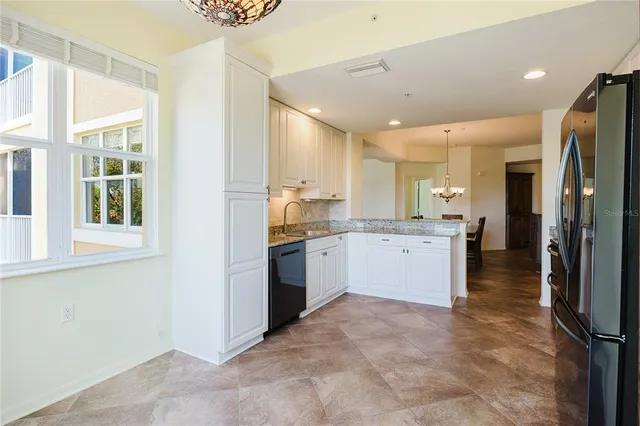 a kitchen with granite countertop a refrigerator and a stove top oven