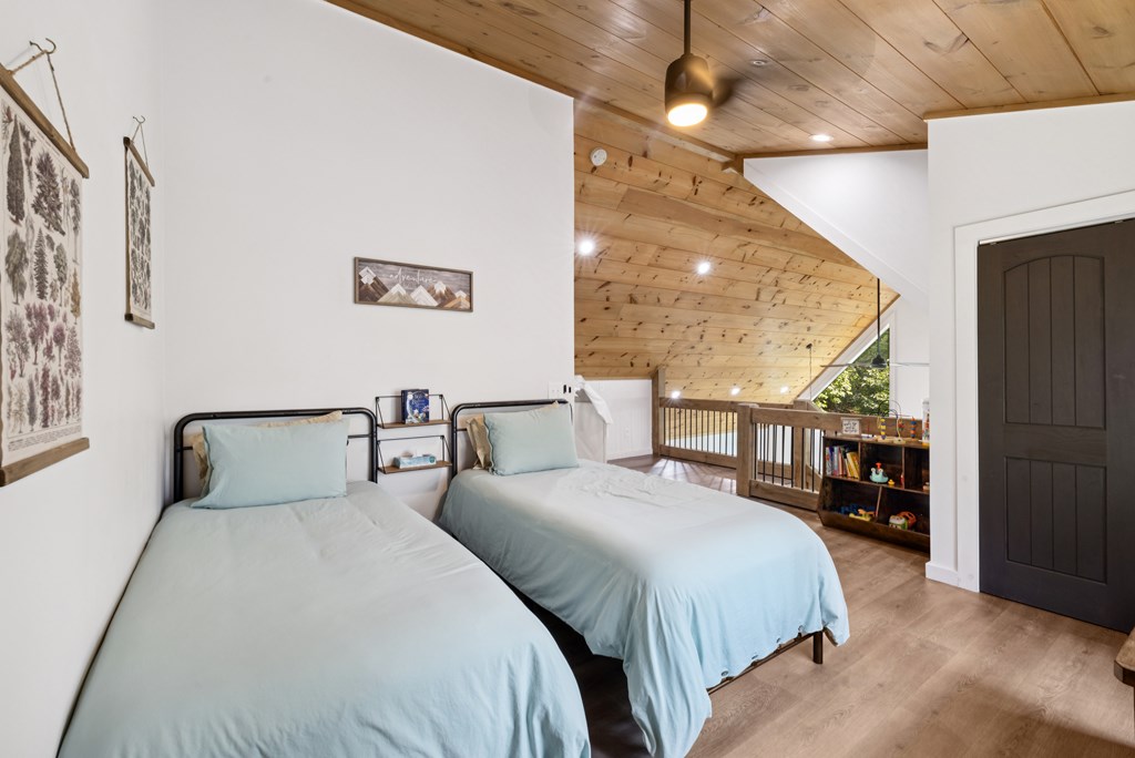 345 Deer Trail Mineral Bluff, GA 30559 - Photo 18 of 31 a bedroom with double bed and a large mirror next to a window