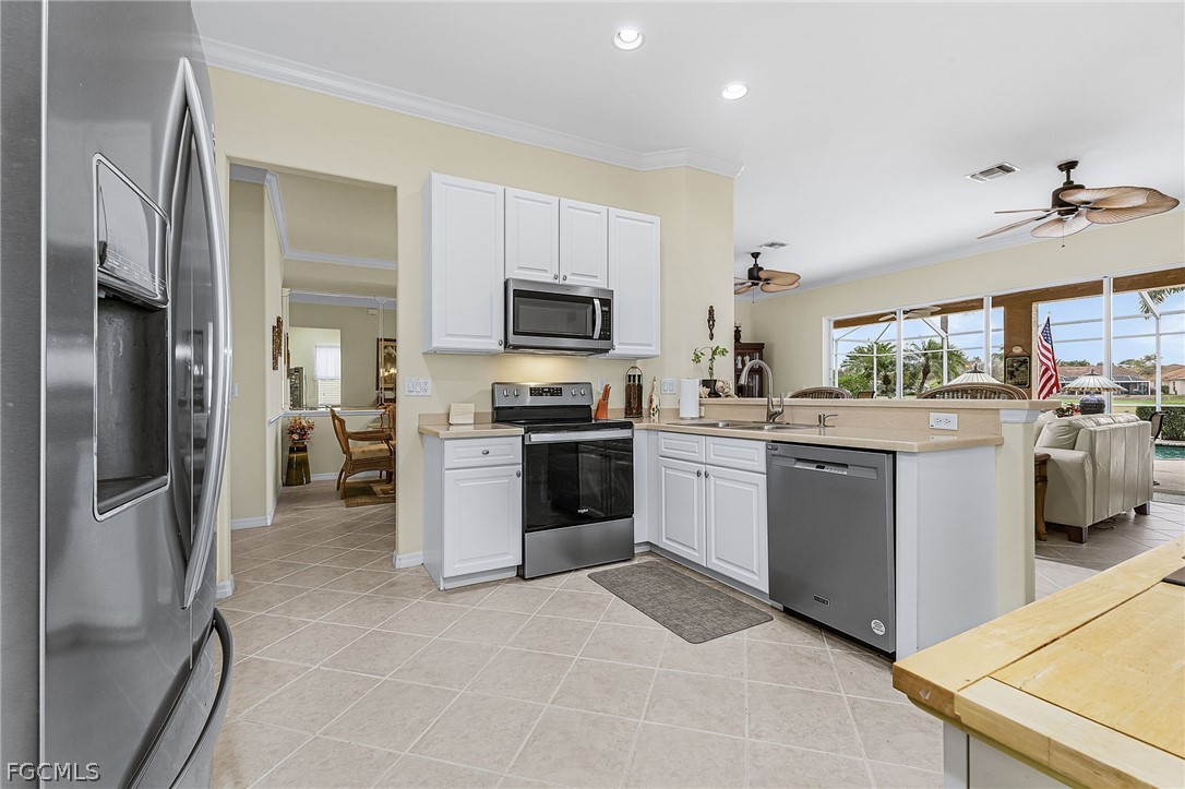2090 Oxford Ridge Circle Lehigh Acres, FL 33973 - Photo 11 of 27 a kitchen with a refrigerator stove and microwave