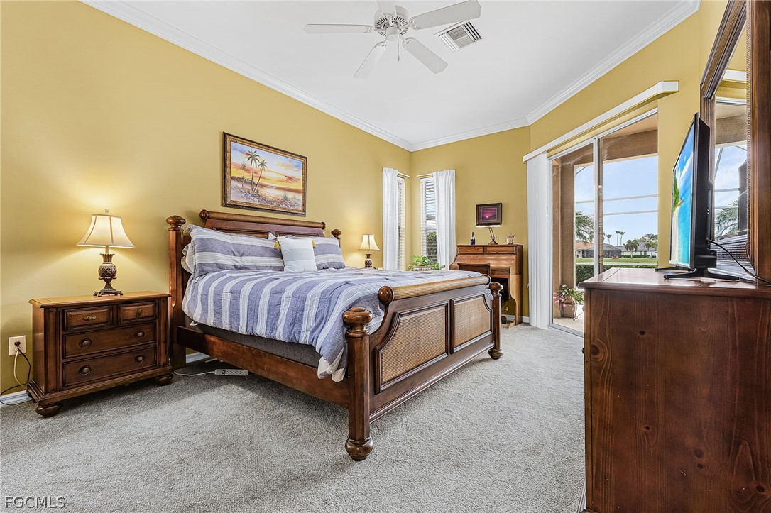 2090 Oxford Ridge Circle Lehigh Acres, FL 33973 - Photo 15 of 27 a bedroom with a bed lamp and a large window