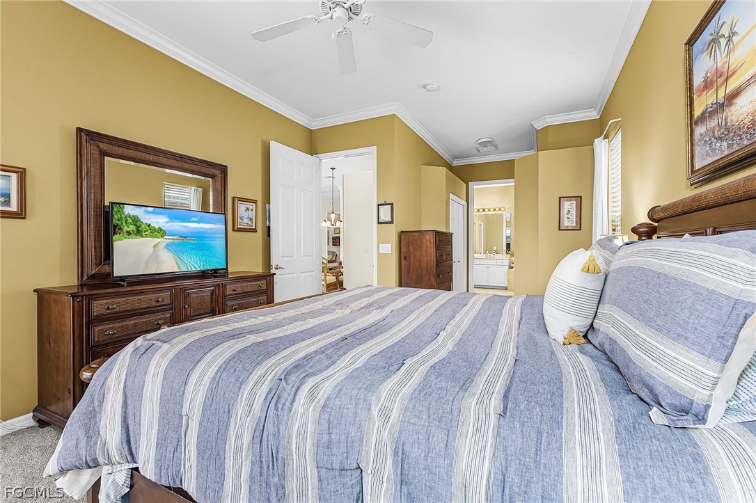 2090 Oxford Ridge Circle Lehigh Acres, FL 33973 - Photo 16 of 27 a bedroom with a bed and a chandelier