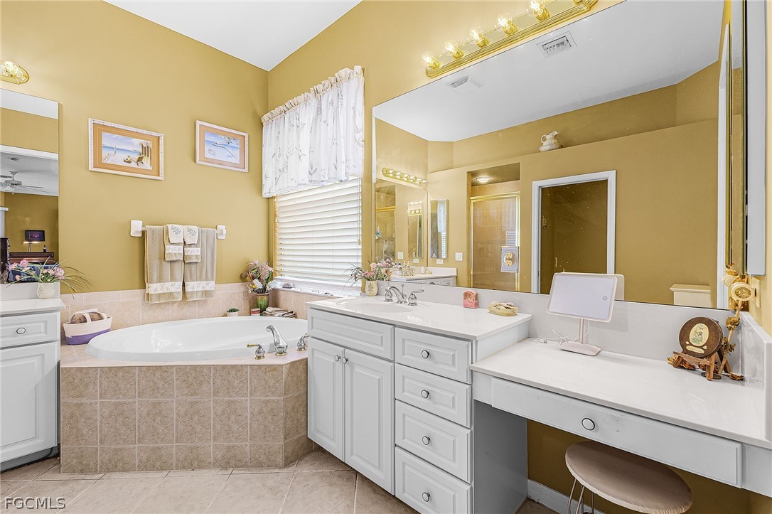 2090 Oxford Ridge Circle Lehigh Acres, FL 33973 - Photo 17 of 27 a bathroom with a tub sink and mirror