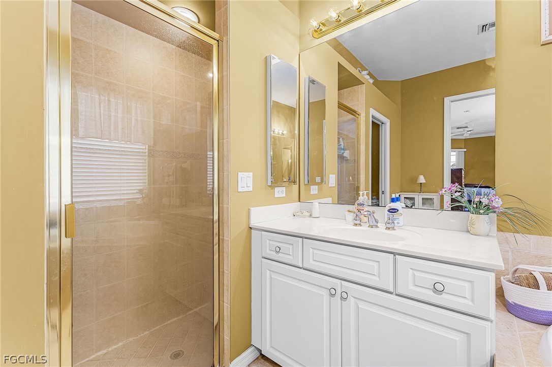 2090 Oxford Ridge Circle Lehigh Acres, FL 33973 - Photo 18 of 27 a bathroom with a double vanity sink mirror and