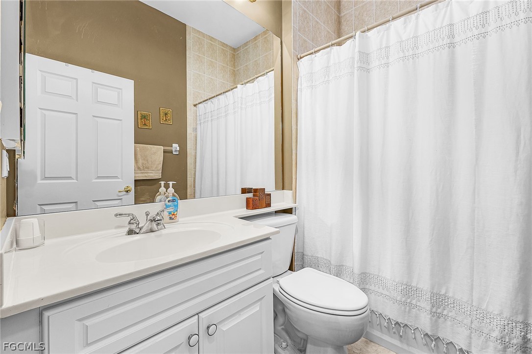 2090 Oxford Ridge Circle Lehigh Acres, FL 33973 - Photo 20 of 27 a bathroom with a sink a toilet and a mirror