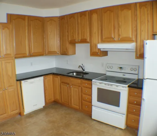 a kitchen with granite countertop stainless steel appliances white cabinets and a sink