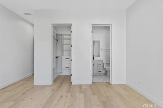 an empty room with closet and wooden floor