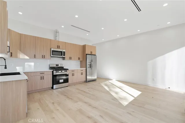 a kitchen with stainless steel appliances a refrigerator stove microwave and cabinets