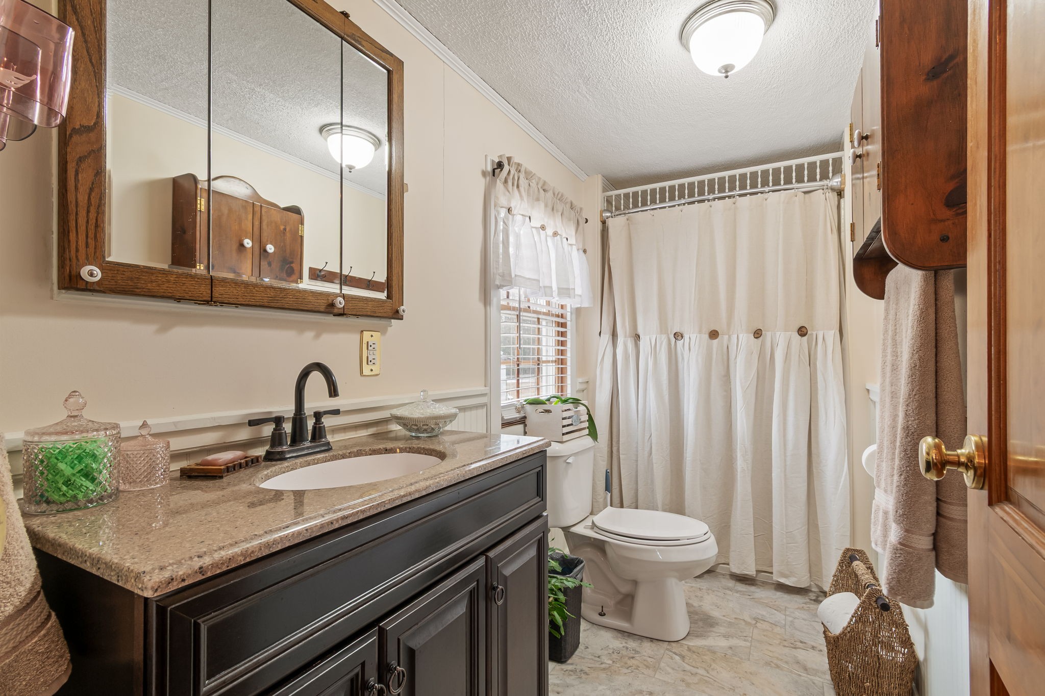 253 Henslee Road Shelbyville, TN 37160 - Photo 18 of 47 a bathroom with a granite countertop sink toilet a mirror and shower