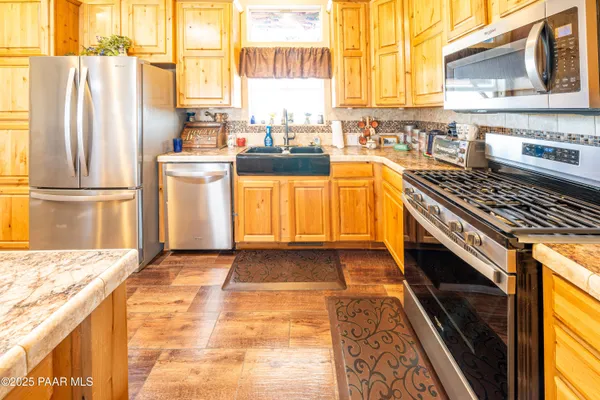 a view of a kitchen with kitchen island granite countertop a sink and counter top space