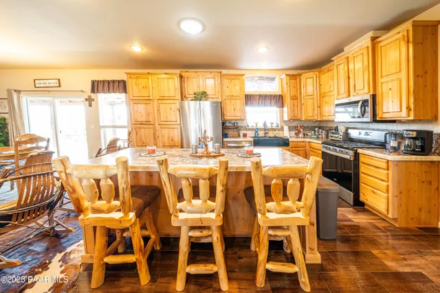 a dining room with wooden floor and large windows