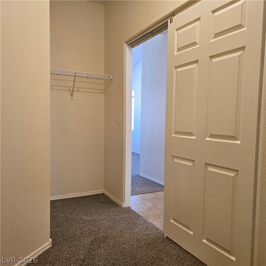 9234 Kingston Road Henderson, NV 89074 - Photo 30 of 38 A deep walk-in closet with ample shelving awaits, providing practical storage solutions.