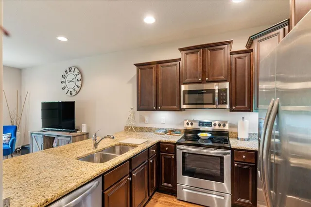 a kitchen with stainless steel appliances granite countertop a sink stove and refrigerator