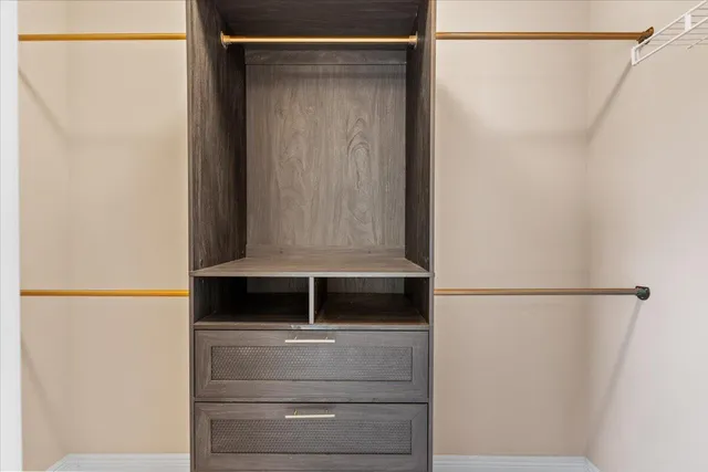 a view of walk in closet with clothes