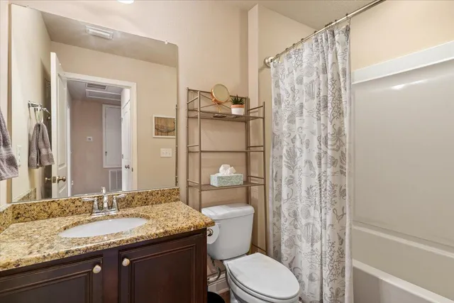 a bathroom with a granite countertop sink toilet and shower