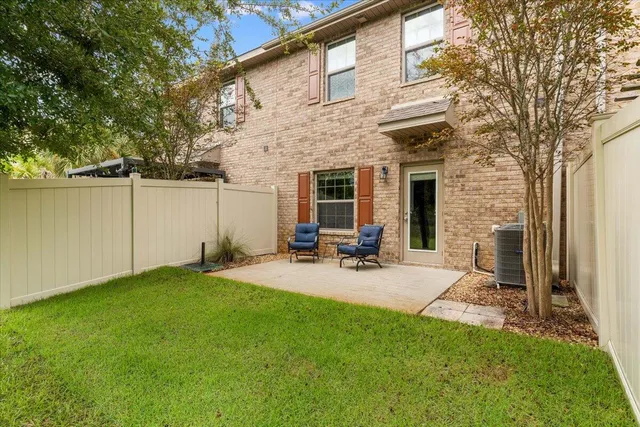 a view of a backyard with table and chairs and wooden fence