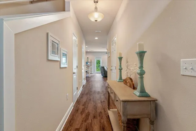a view of a hallway with wooden floor and staircase