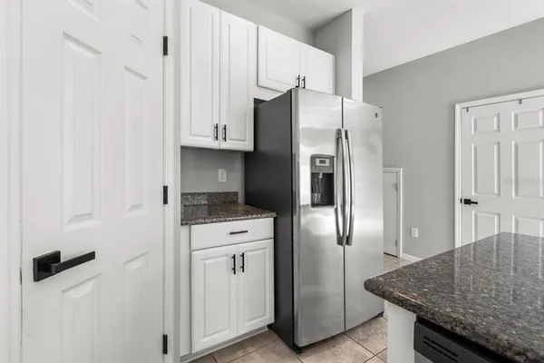 a kitchen with stainless steel appliances granite countertop a refrigerator and a stove