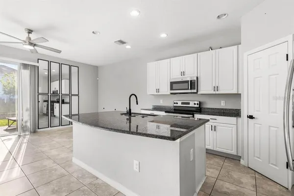 a kitchen with stainless steel appliances granite countertop a sink and a refrigerator