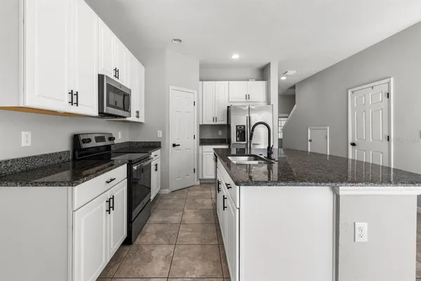 a kitchen with stainless steel appliances granite countertop a sink stove and cabinets